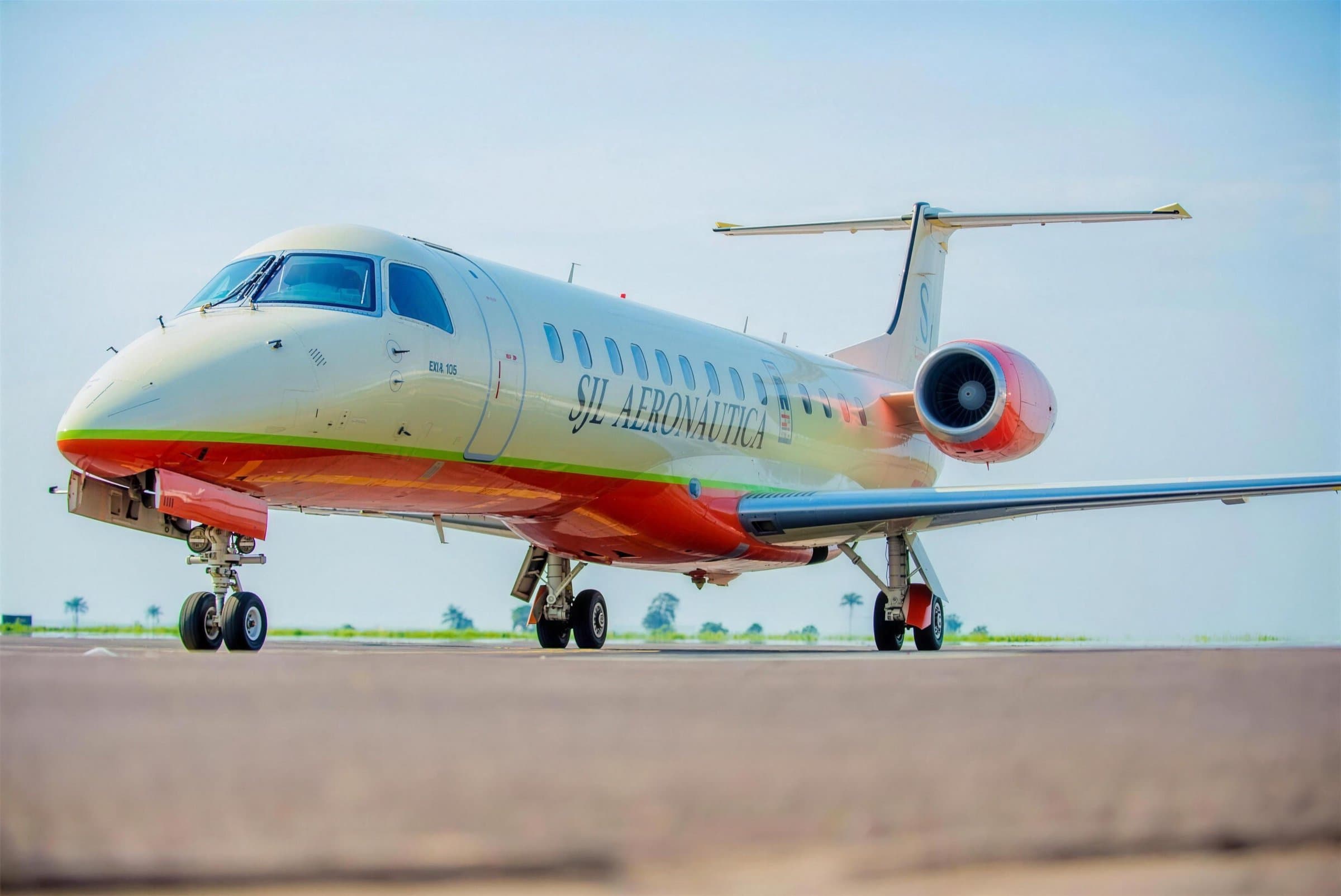 Embraer 135 da SJL Aeronáutica na placa, com a livraria creme e laranja